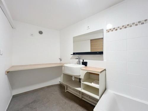 a white bathroom with a sink and a mirror at Charmant T2 Oullins centre avec terrasse in Oullins