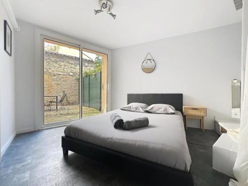 a bedroom with a bed and a large window at Charmant T2 Oullins centre avec terrasse in Oullins