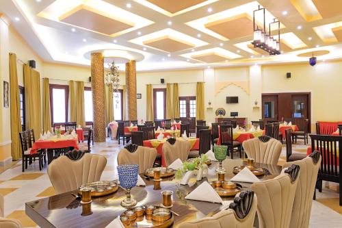 een feestzaal met tafels en stoelen in een restaurant bij Syna Heritage Hotel in Khajurāho