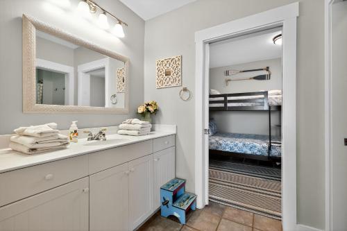 a bathroom with a sink and a mirror and a bunk bed at After Dune Delight in Kure Beach