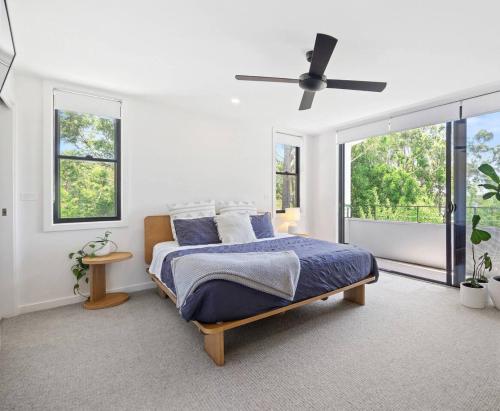 a bedroom with a bed and a ceiling fan at Woodalla Way - Family Coastal Duplex Walk to Beach in Narrawallee