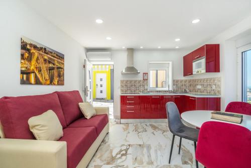 a living room with a red couch and a table at Maredimo Village Casa 3 in Porto