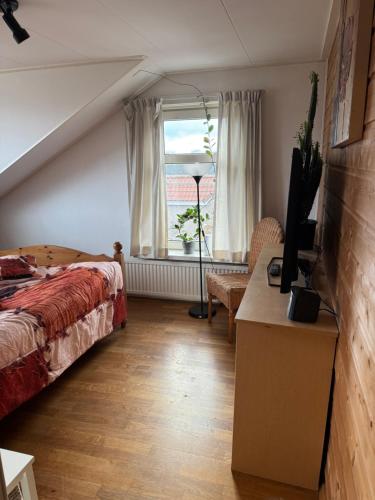ein Schlafzimmer mit einem Bett und einem Fenster in der Unterkunft Bed en breakfast in Stad aan ʼt Haringvliet