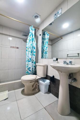 a bathroom with a toilet and a sink at Hotel Las Americas in Cuenca