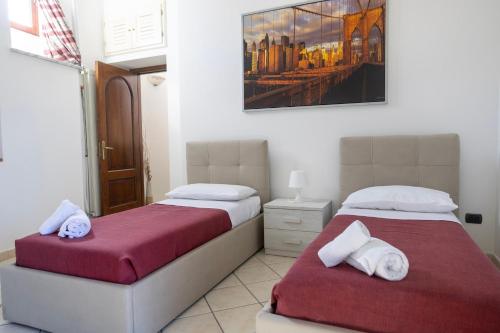 a bedroom with two beds and a painting on the wall at Al Primo Piano in Forio d'Ischia