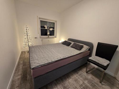 ein Schlafzimmer mit einem Bett und einem Stuhl und einem Fenster in der Unterkunft Weierbacher Panorama in Idar-Oberstein