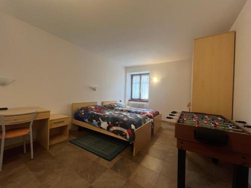 a bedroom with two beds and a desk and a table at Casa Brenta - Alpine Charm in Madonna di Campiglio