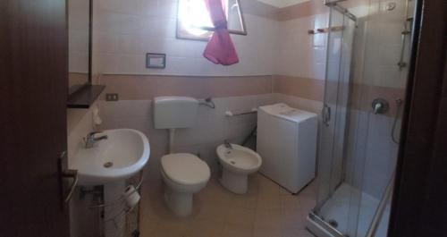 a bathroom with a toilet and a sink and a shower at Casetta La Meridiana in San Vito lo Capo