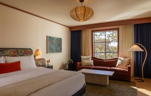 una camera d'albergo con letto, divano e finestra di Hotel Daphne a Houston