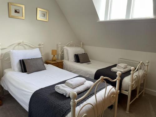 2 aparte bedden in een kamer met 2 ramen bij Monastery 17 in Fort Augustus