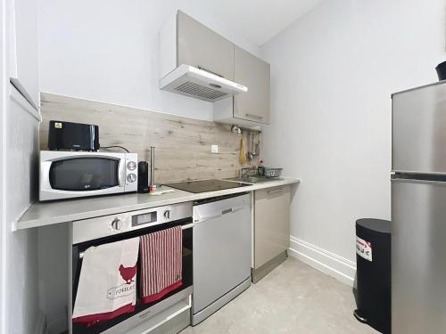 a small kitchen with a microwave and a stove at Appartement confortable Oullins centre in Oullins