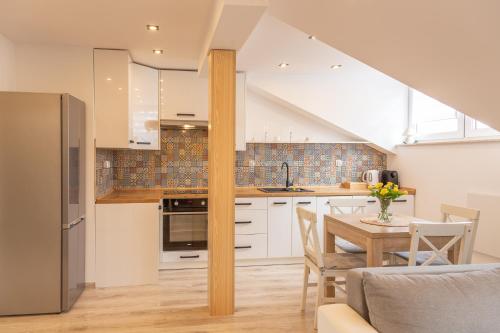 a kitchen with white cabinets and a table with chairs at The Lion Rooms in Ustroń