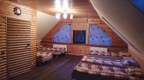 ein Dachzimmer mit zwei Betten und zwei Fenstern in der Unterkunft Atsalama puhketalu kompleks in Atsalama