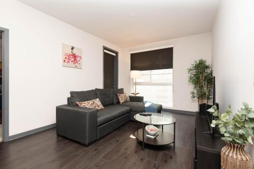 a living room with a couch and a table at Lovely 3BR Apt With Balcony And Rooftop Pool Plus Views in Los Angeles