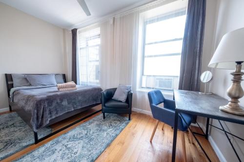 a bedroom with a bed and a desk and a chair at 3BR apt two blocks to Central Park elevator, laundry, virtual doorman in New York