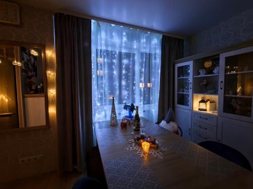 Una mesa de comedor con una ventana con luces en Narva art-object apartment, en Narva