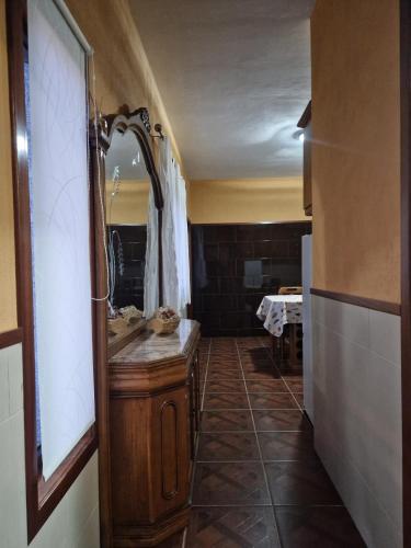 ein Badezimmer mit einem Waschtisch aus Holz und einem Spiegel in der Unterkunft Quinta do silva in Celorico de Basto