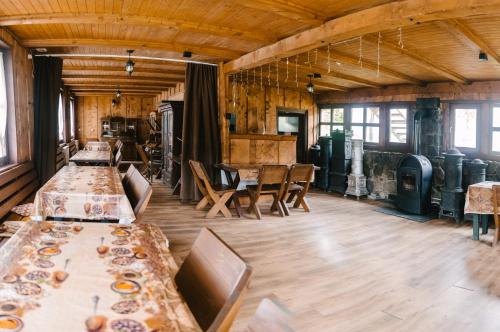 ein großer Raum mit Tischen und Stühlen und Fenstern in der Unterkunft Silver Villa in Băile Tuşnad