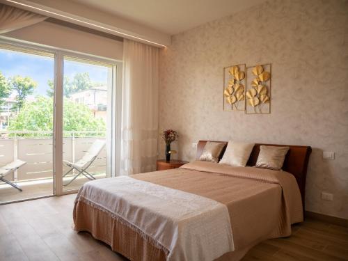 ein Schlafzimmer mit einem Bett und einem großen Fenster in der Unterkunft Villa Butterfly in Battaglia Terme