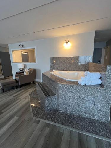 a bathroom with a tub with towels on a counter at The Grand Hotel Spindletop in Beaumont