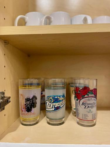 four empty glasses sitting on a shelf at Cozy Home Apartments in Louisville