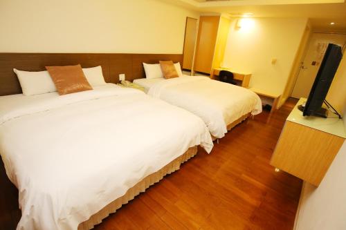 Postel nebo postele na pokoji v ubytování Tai Shinu Hotel