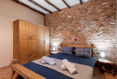 a bedroom with a blue bed and a brick wall at Villa Nestor in Platamonas