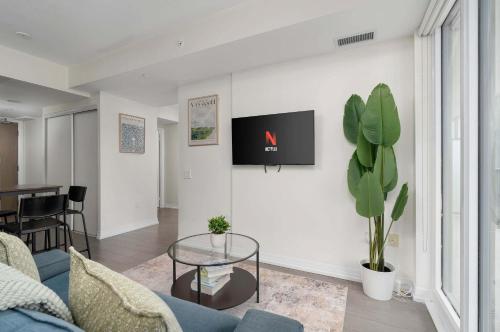 ein Wohnzimmer mit einem blauen Sofa und einem Glastisch in der Unterkunft Chic 2BR Condo Toronto Core Steps to Eaton Centre in Toronto