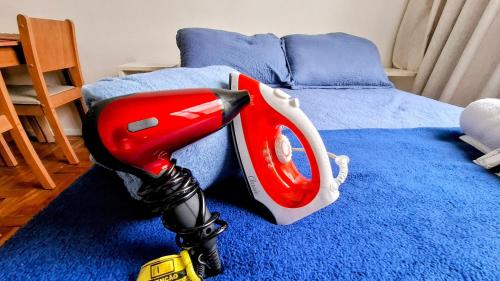 une machine à jouets rouge et blanche sur un lit dans l'établissement Sunrise Flamengo - 4 Hóspedes, Metrô e Privativo!, à Rio de Janeiro