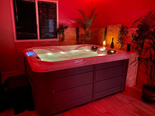 a red bathroom with a tub in a red room at A La Mare du Vieux Chêne in Bellegarde-Poussieu