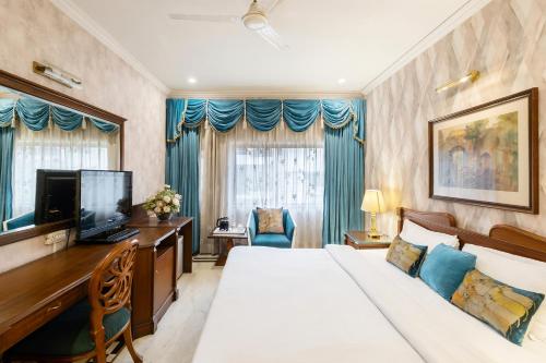 una camera d'albergo con un letto, una scrivania e una televisione di Hotel Kwality Regency a Chandīgarh