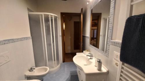 a bathroom with a sink and a toilet and a mirror at La Corte Antica in Pienza