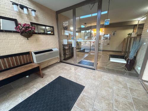 a room with a bench and a glass door at Candlelight Inn by Capital O Scottsbluff in Scottsbluff