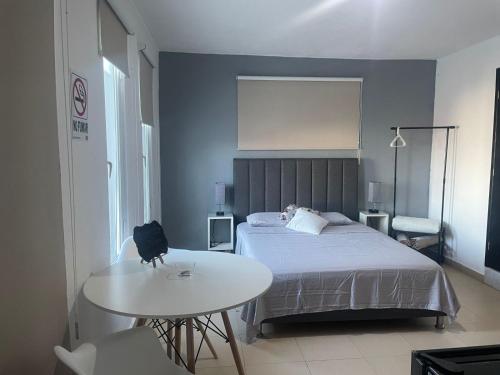 - une chambre avec un lit et une table blanche dans l'établissement Departamento TUL, à Mérida