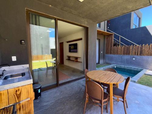 a dining room with a table and a swimming pool at MHV Milagres - Casa Maria, Refugio em condomínio a poucos metros da paradisíaca praia do Marceneiro! in Passo de Camarajibe
