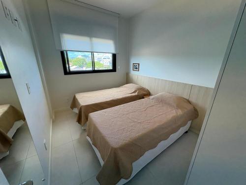 a room with two beds and a window at Resort piscina aquecida suíte e churrasqueira in Florianópolis