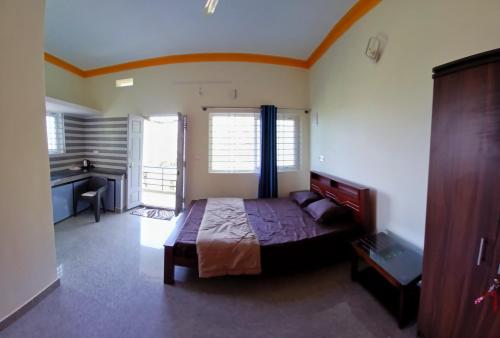 ein Schlafzimmer mit einem Bett und einem Schreibtisch darin in der Unterkunft The Town Cascade in Madikeri