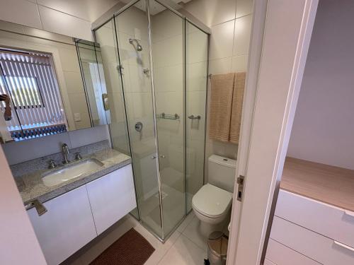 a bathroom with a shower and a toilet and a sink at Resort piscina aquecida suíte e churrasqueira in Florianópolis