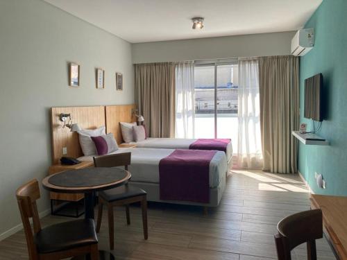 a hotel room with a bed and a table at Modern and Warm Apartment in Buenos Aires