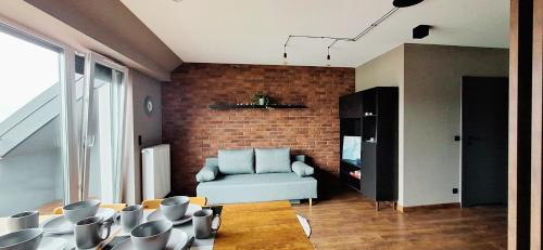 Una sala de estar con un sofá y una pared de ladrillos. en Easy Stay Strzeszyn, en Poznan