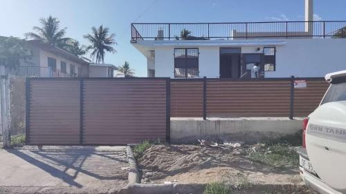 uma casa com uma cerca de madeira na frente em Priscilla Apartment家庭公寓两居室 步行到麦当劳 近超市餐厅 免费停车位 em Nadi