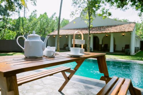 a wooden table with a tea kettle and cups on it at Matt-Jay Villa -Baddegama in Baddegama