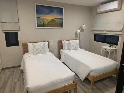 a room with two beds and a painting on the wall at 2 Bedroom Apartment in Naiyang - The Title Residences, Naiyang in Nai Yang Beach