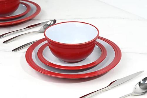 Dos platos rojos y un cuenco rojo sobre una mesa en Caftop Homes Manchester, en Mánchester