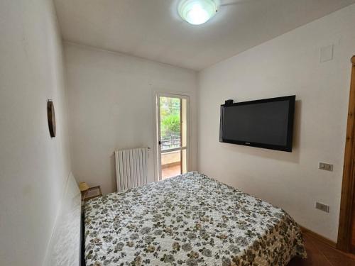 a bedroom with a bed and a flat screen tv at Chalet Erminia in Castel di Sangro