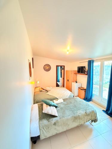 a bedroom with two beds and a window at Maison Bon Séjour in Livry-Gargan
