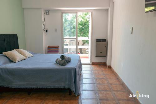 ein Schlafzimmer mit einem Bett und einem großen Fenster in der Unterkunft Monoambiente en ubicación estratégica in Santa Fe
