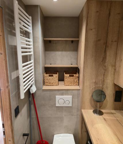a bathroom with a toilet and baskets on the wall at Le 1954 La Rosière in La Rosière