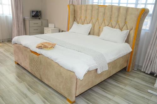 une chambre avec un grand lit avec une tête de lit en bois dans l'établissement Jayhawk House, à Nairobi