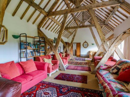 a living room with pink furniture and wooden beams at Gaer Hall in Guilsfield